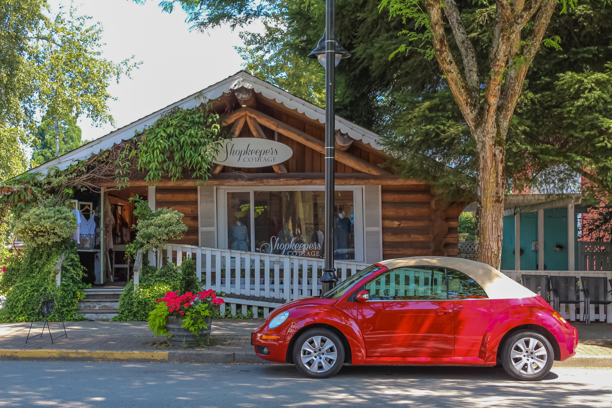 Shopkeepers Cottage storefront with a bright red car parked outside